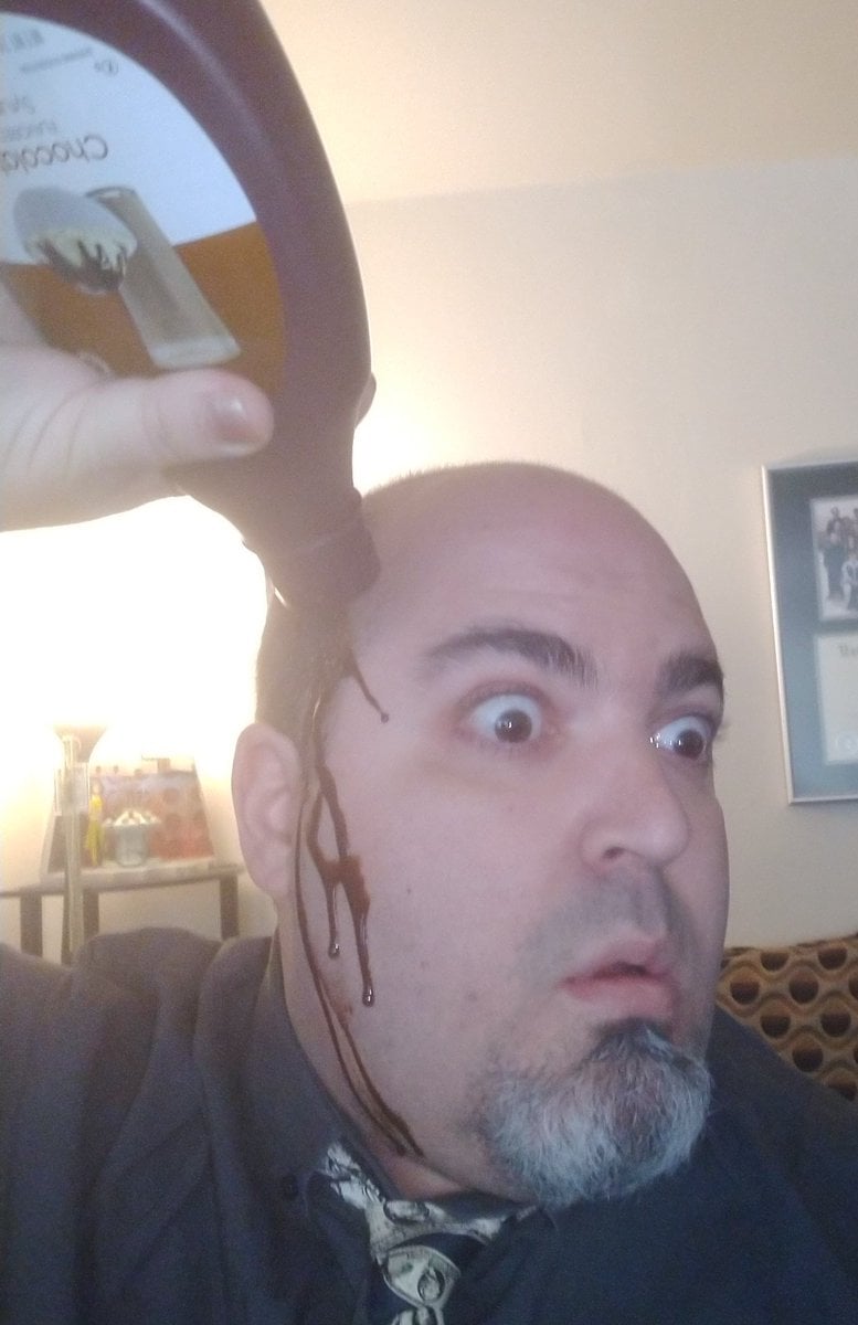 Photo of the undersigned looking befuddled as he pours a bottle of chocolate syrup over his big bald head so that it runs comically down the side of his face, mimicking the infamous shot of Rudy Giuliani from the disastrous press event in which his hair dye was dripping down his own face.