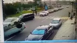 Speeding car nearly kills a scooterist in a crosswalk, and flips after veering