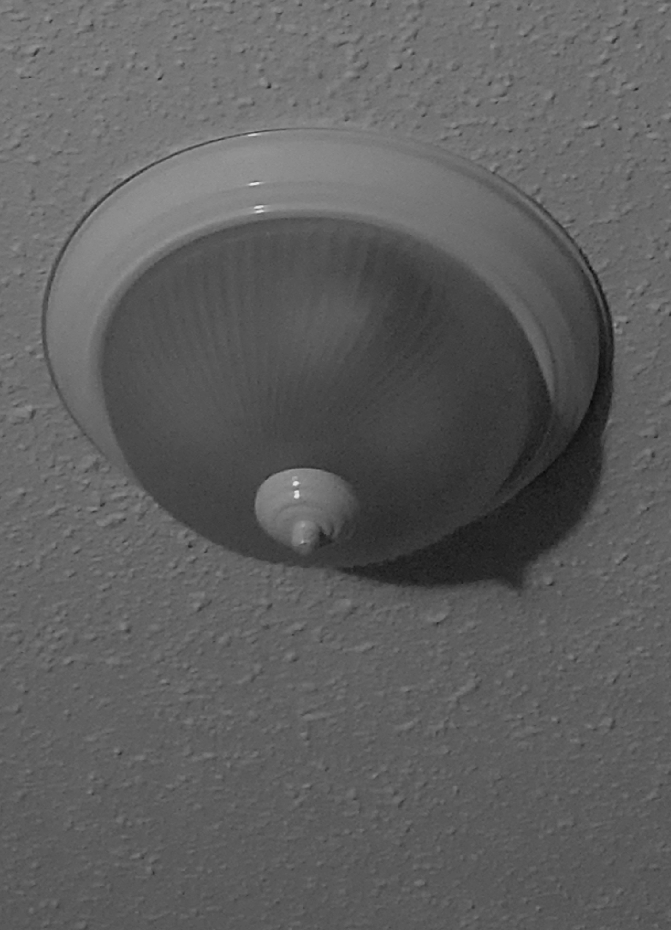 image of a dome light cover with a protruding "nipple" at it's highest point-- making it breast-like in appearance.