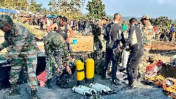 Indian army divers retrieve the body of one of at least 9 miners trapped in a flooded coal mine