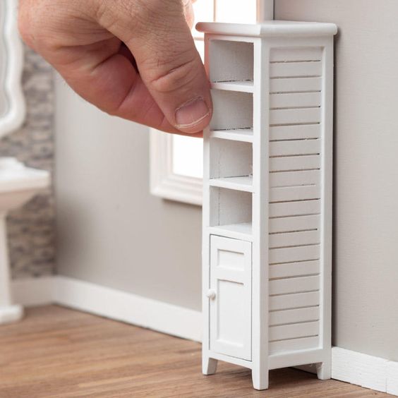 hand touching bathroom wooden shelving painted white