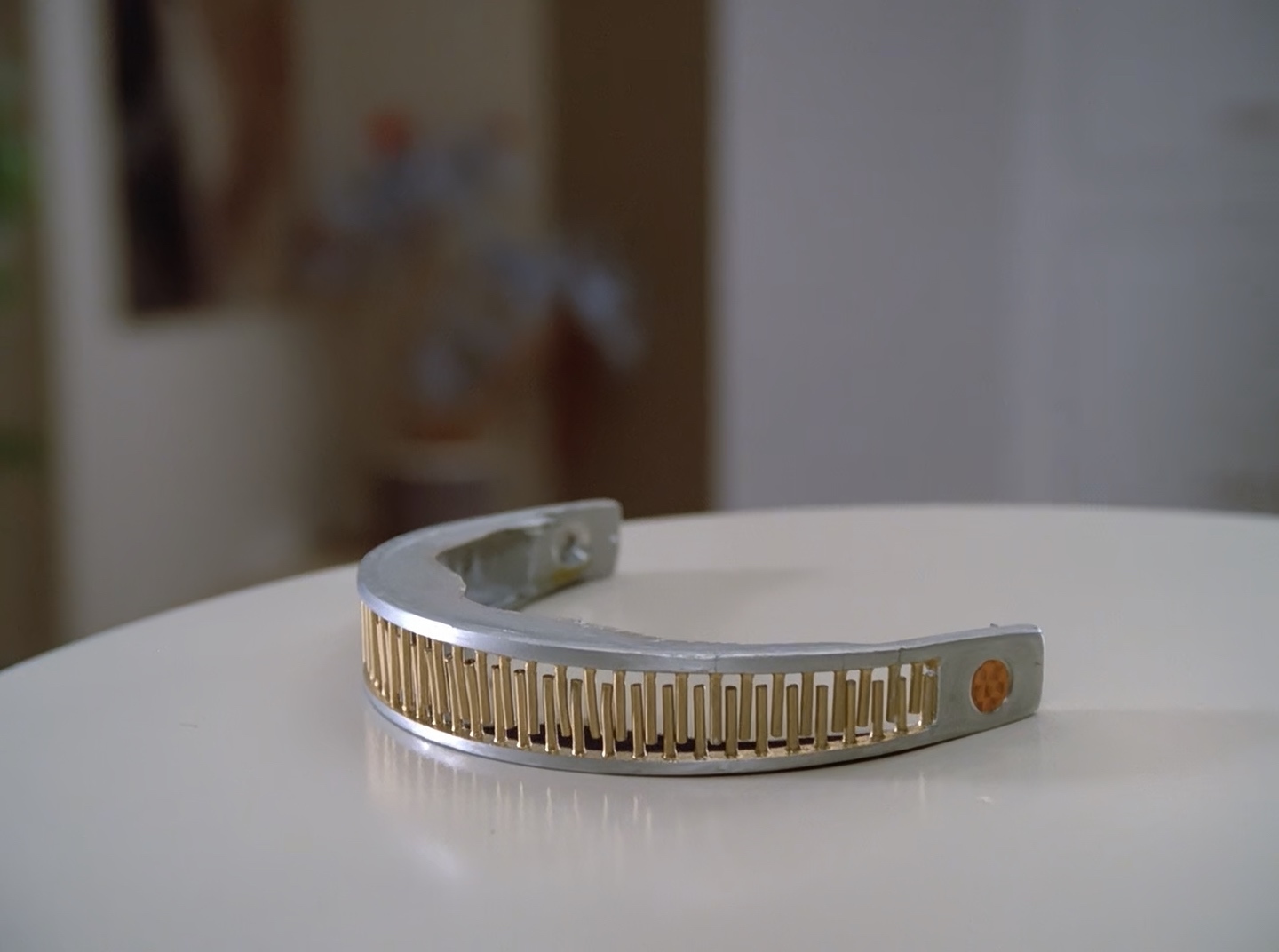 Geordi LaForge's Visor sitting on a table in the sickbay of the Enterprise-D. In high definition, it is very clear that it is a plastic hair crimp painted silver and decorated.