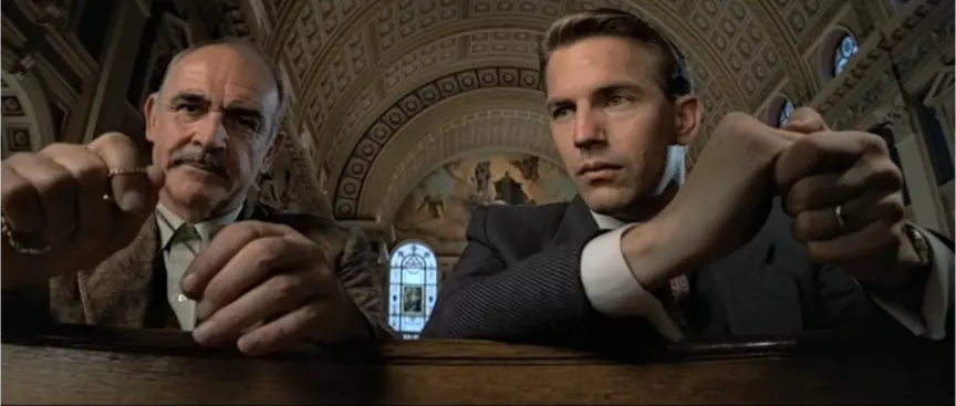 Movie scene from Untouchables. Sean Connery and Kevin Costner in a church sitting in pews. 