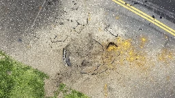 A US bomb from World War II explodes at a Japanese airport, causing a large crater in a taxiway