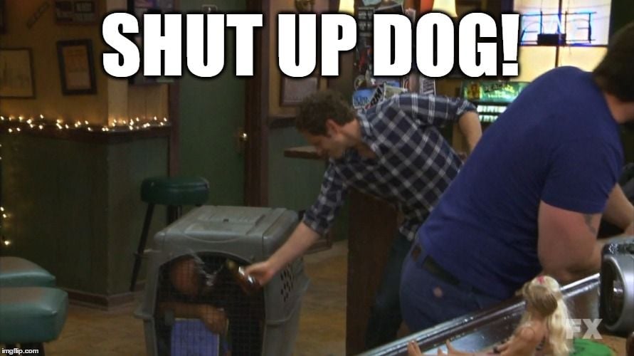 Man in a dog crate getting water splashed into him by a man yelling "shut up, dog."