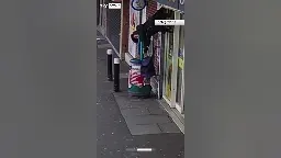 Woman lifted by shop shutters