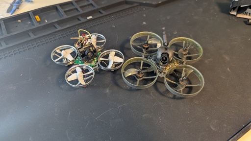 Photo of two quadcopters, a DIY Tiny Whoop from 2016 and a more recent ready-to-fly Happymodel Mobula7