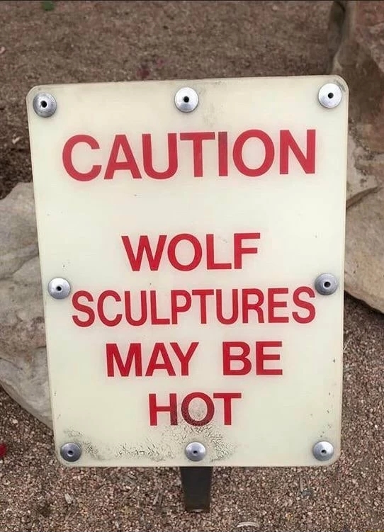 Caution sign - wolf sculptures may be hot