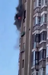 Person tries to land on a balcony below their burning apartment