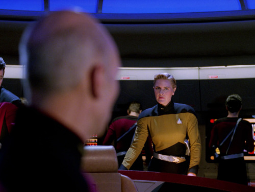Captain Picard on the bridge of the Enterprise-D in an alternate timeline, looking over his shoulder to the Security station and seeing Tasha Yar standing in Worf's place.