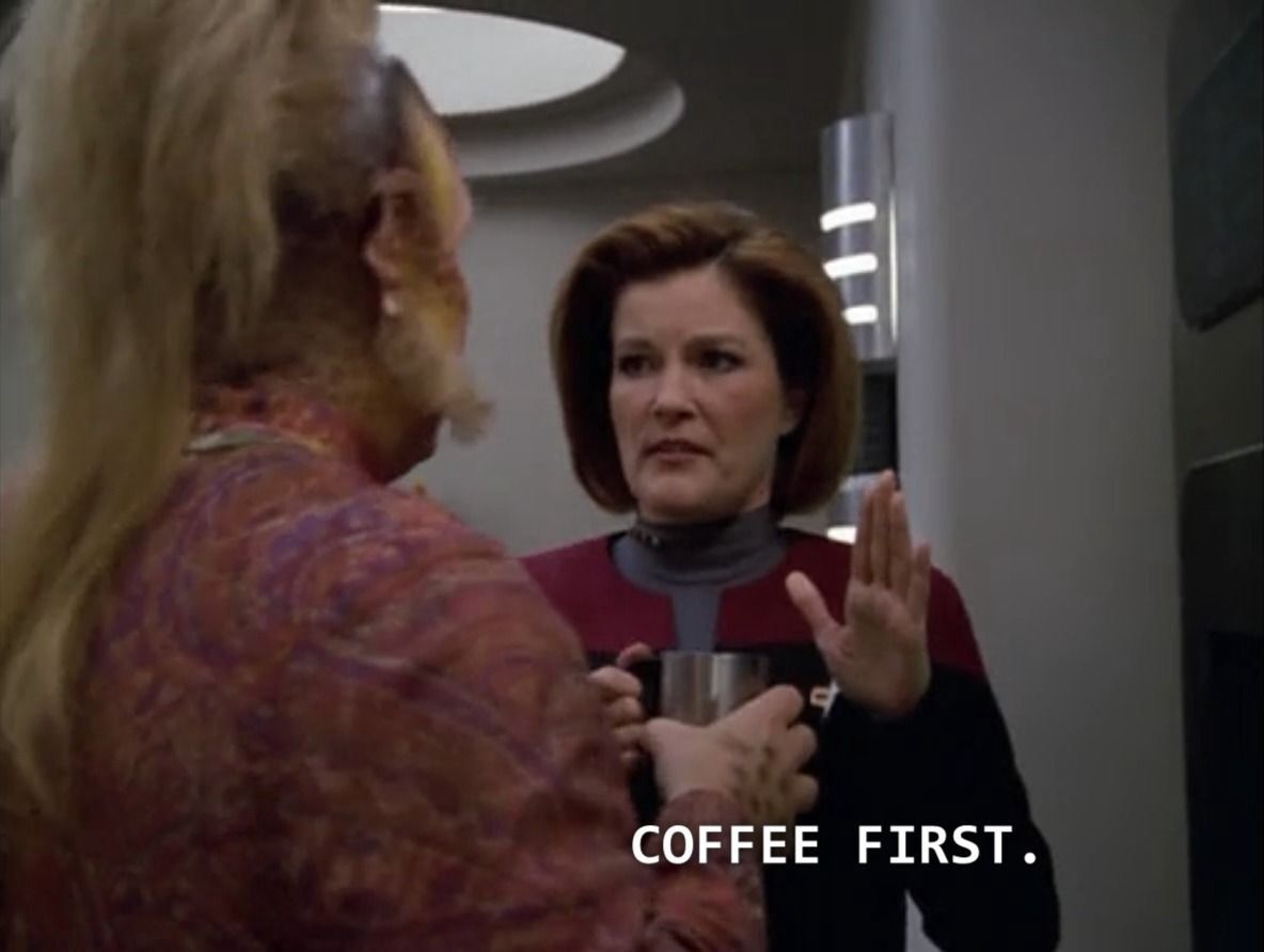 Captain Janeway in Voyager’s mess hall, holding her hand up to Neelix who is trying to talk to her and saying, “Coffee first.”