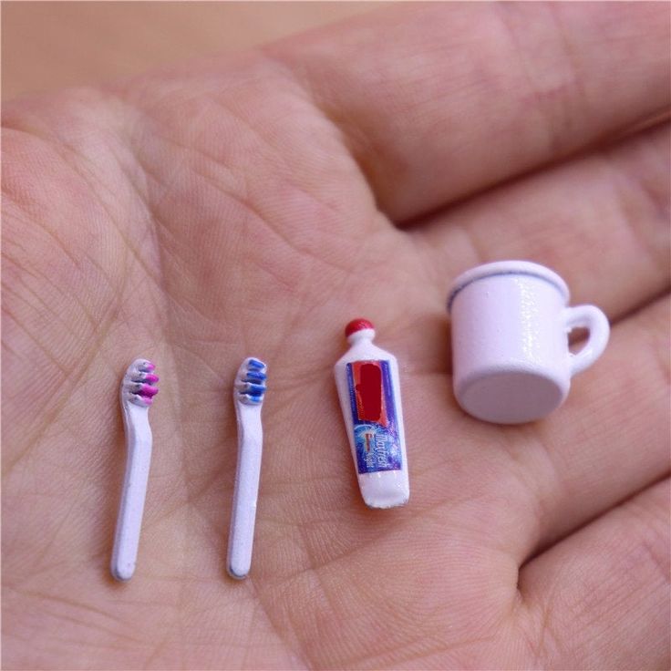 2 toothbrushes, toothpaste, and a cup