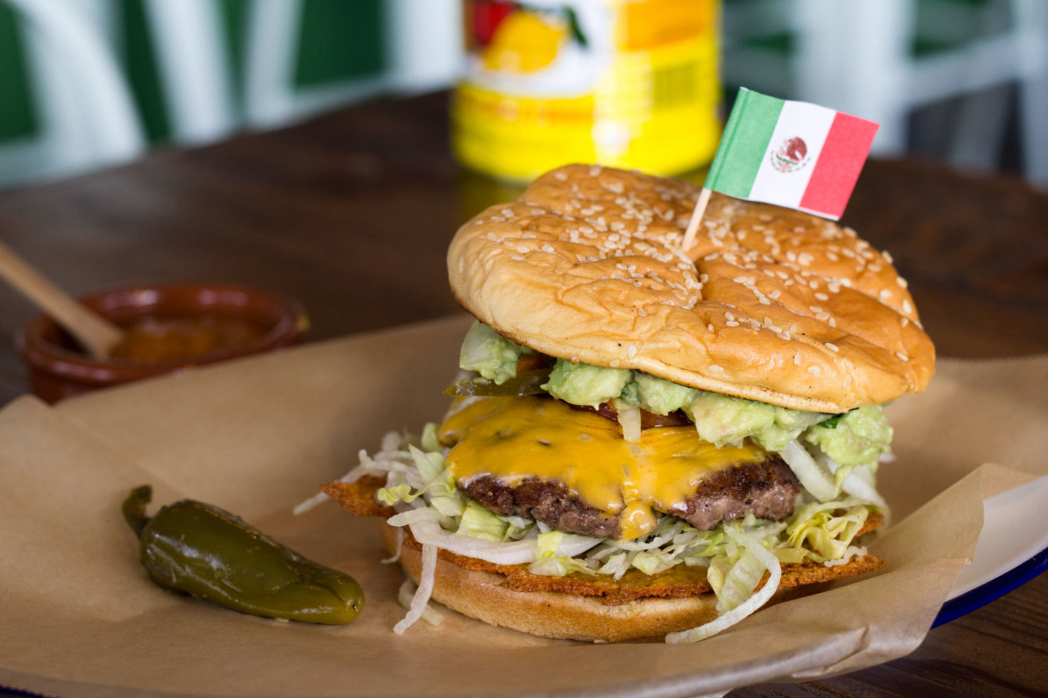 Güero’s Mexican street burger, complete with fried American cheese, habanero slaw, pickled jalapeno, tamarind-habanero-roasted tomato, and a big dollop of guacamole.